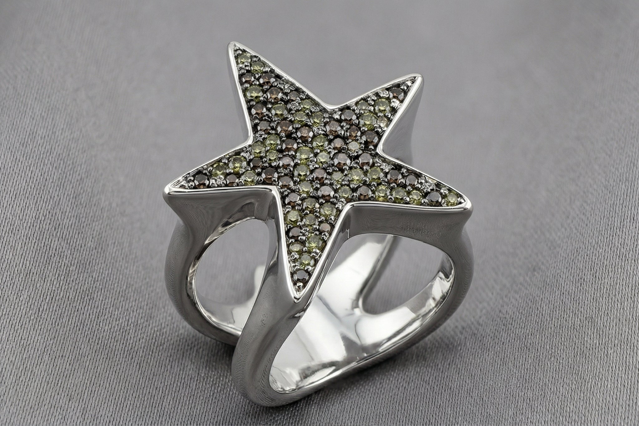 Star-shaped silver ring with embedded stones on a gray background