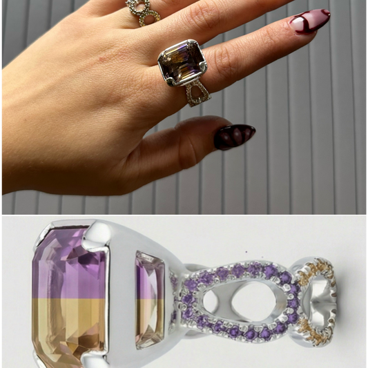 Hand wearing a ring with a purple gemstone against a neutral background